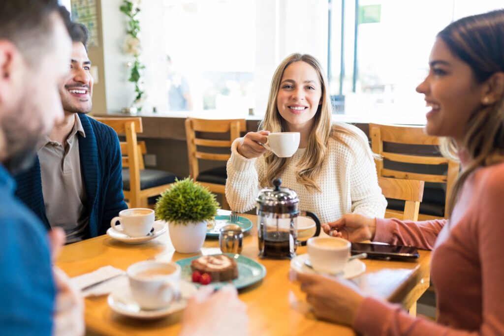 femeie zambitoare care este la o cafea cu prietenii